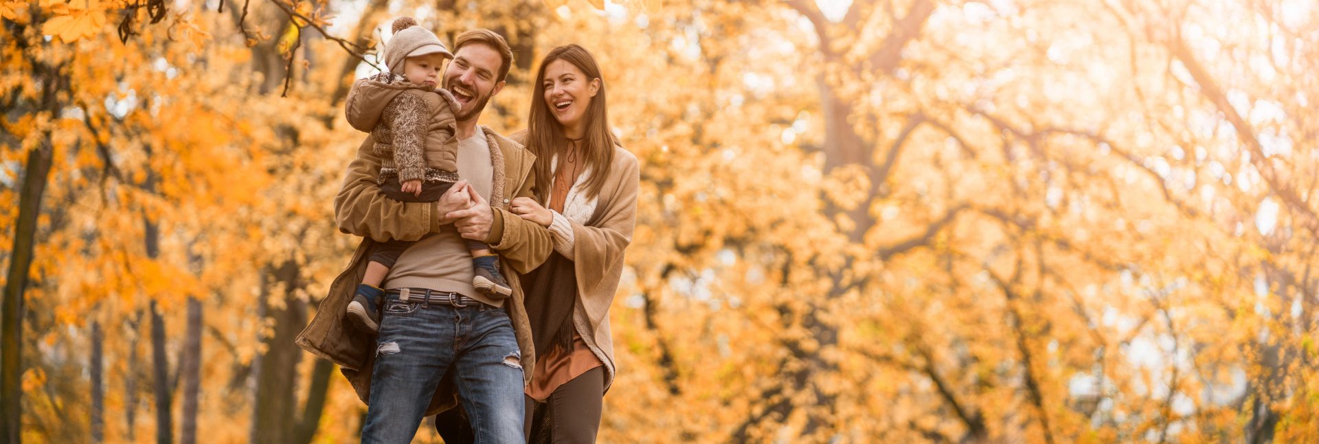 Family Walking In Fall Leaves